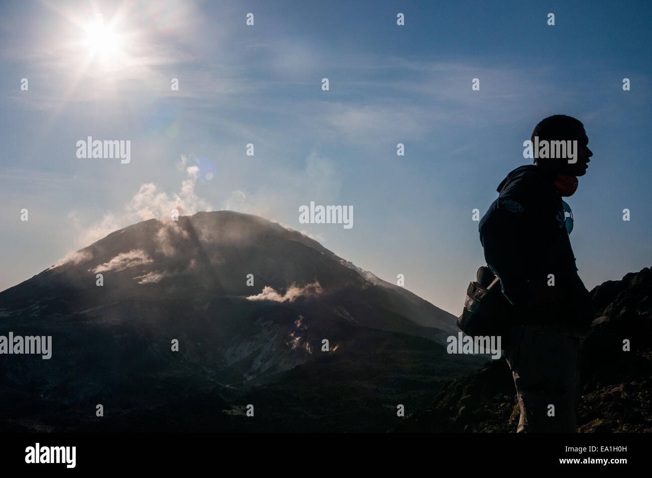 Un grimpeur se trouve sur le bord de la caldera, dans un contexte d'activité volcanique du volcan du Mont Lewotolok à Lembata, à Nusa Tenggara, en Indonésie. Banque D'Images