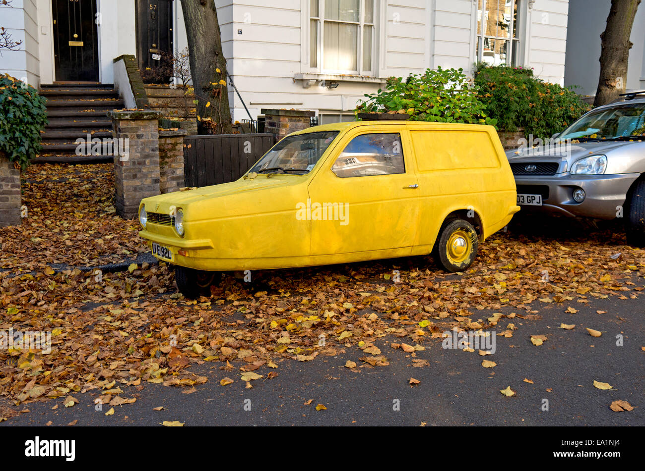 Un jaune vif Reliant Robin Classic voiture garée dans une rue. Banque D'Images