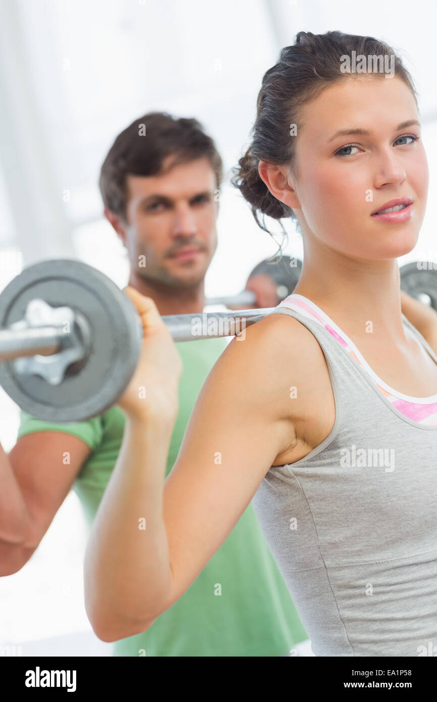 Mettre en place des barres de levage young couple in gym Banque D'Images