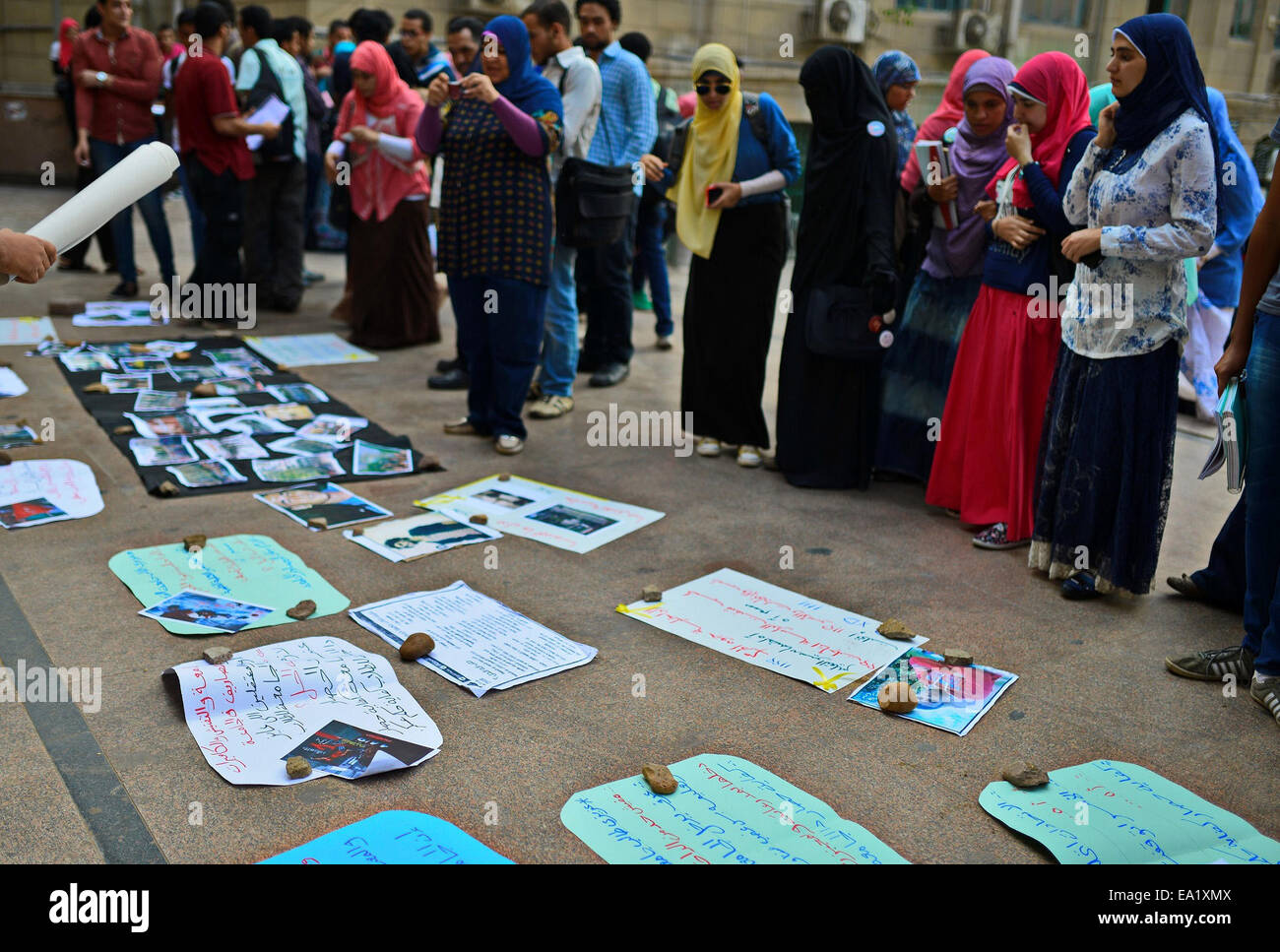 Le Caire, Égypte. 5Th Nov, 2014. Stand égyptien regarder des images et des pancartes portées dans une rue d'un spectacle organisé par des étudiants contre l'arrestation des étudiants des universités, et contre le régime militaire, à l'extérieur de l'Université du Caire le 05 novembre, 2014 © Amr Sayed/APA/Images/fil ZUMA Alamy Live News Banque D'Images