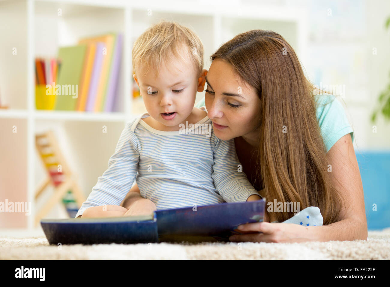 Mère lit un livre pour enfant à la maison Banque D'Images