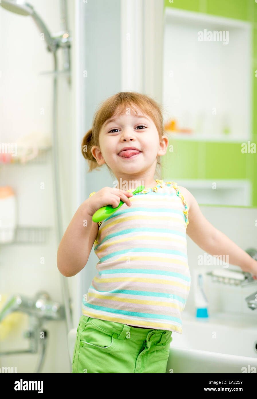 Fille enfant se brosser les dents dans la salle de bains Banque D'Images