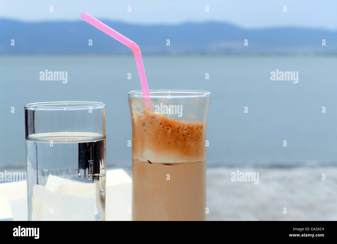 Deux verres d'eau et café sur une table près de la rive du lac Banque D'Images