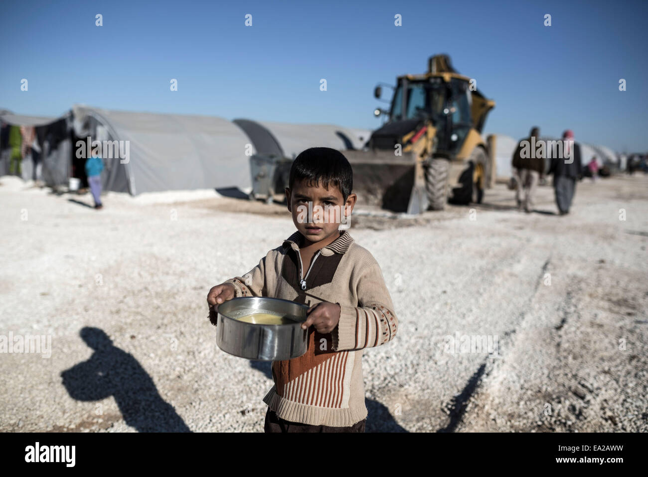 Suruc, Turquie. 05Th Nov, 2014. Un garçon de Kurdes syriens Kobane le regarde il porte un pot de nourriture dans un camp de réfugiés dans la ville de Suruc Turkey-Syria près de la frontière le 5 novembre 2014. Credit : Konstantinos Tsakalidis/Alamy Live News Banque D'Images