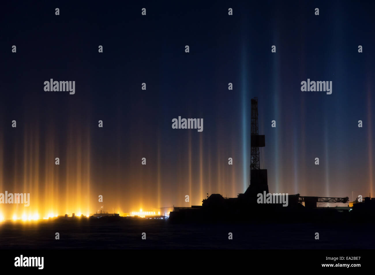 Piliers de lumière et d'un appareil de forage dans le gisement de Prudhoe Bay, Deadhorse, versant nord, l'Alaska arctique, l'hiver Banque D'Images