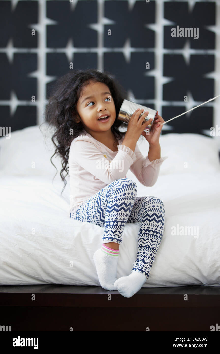 Une jeune fille est en train de jouer avec un appareil de communication CAN et string ; San Francisco, Californie, États-Unis d'Amérique Banque D'Images