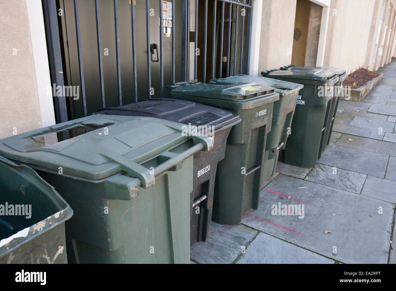 Les poubelles alignées contre un mur. Banque D'Images