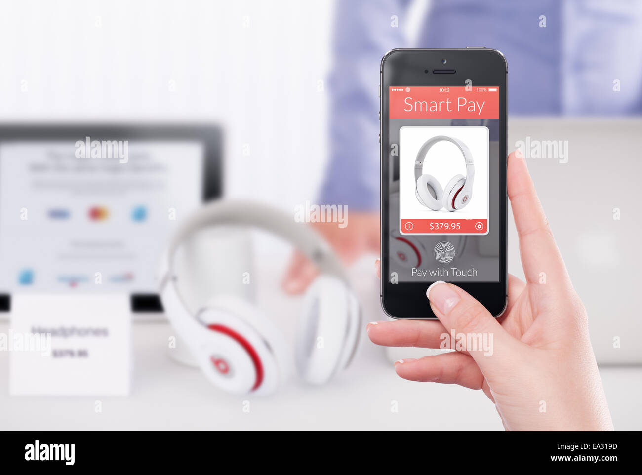 Femme hand holding black téléphone intelligent avec smart nfc application paie. Magasin floue avec le vendeur et gadgets sur le backg Banque D'Images