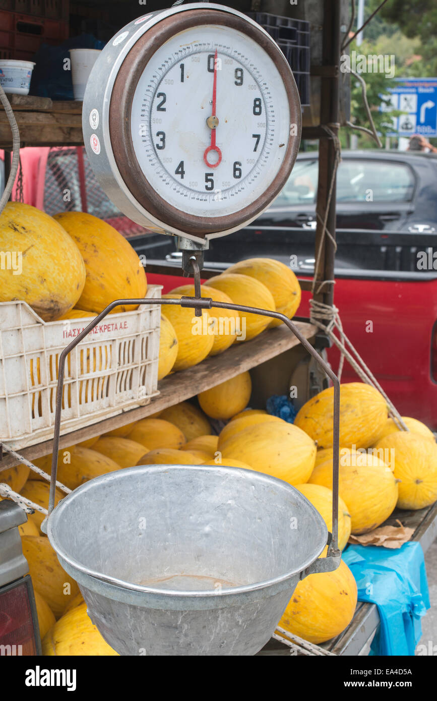 La vente de melons sur le marché. Poids avec Balance Banque D'Images