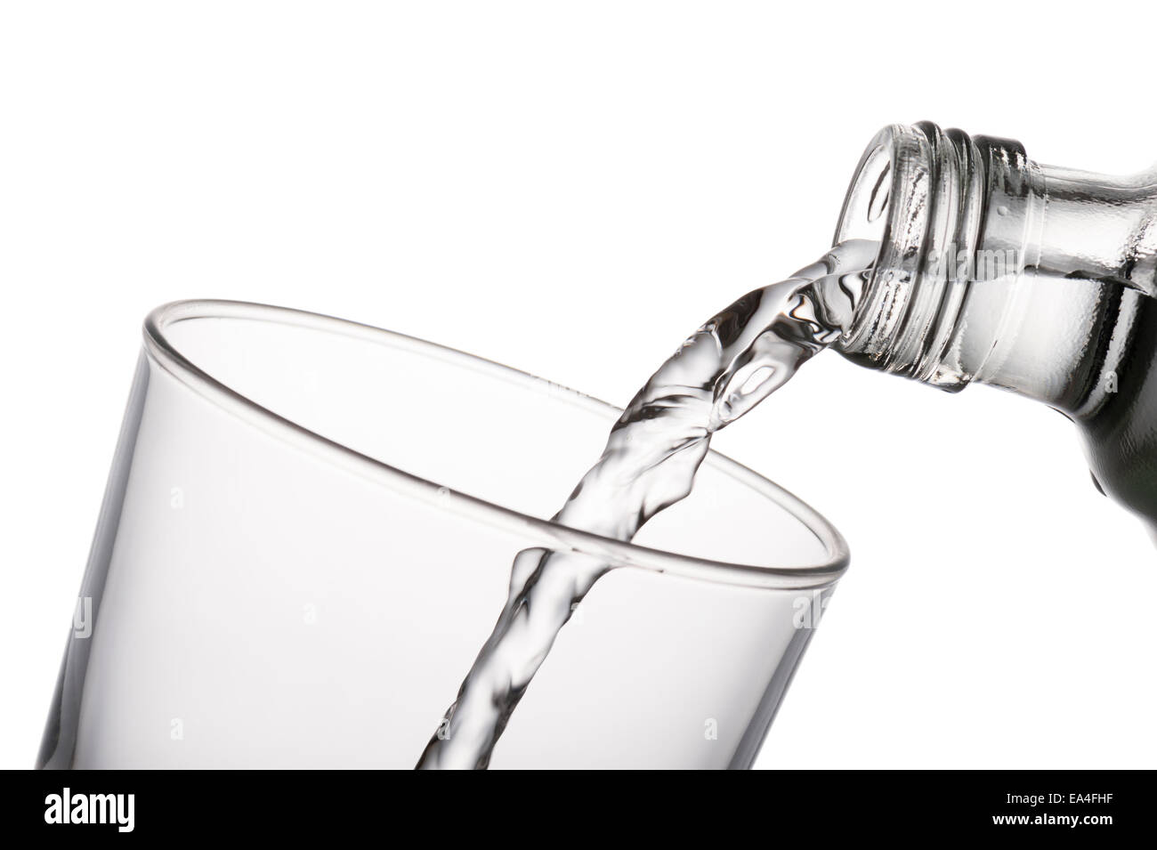 Verser de l'eau dans un verre d'une carafe, sur fond blanc Banque D'Images