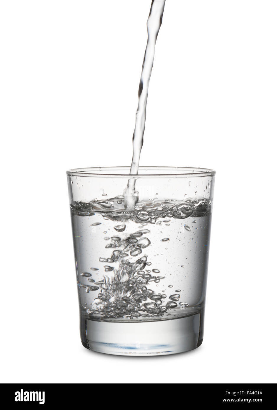 Jet d'eau qui remplit un verre, sur fond blanc Banque D'Images