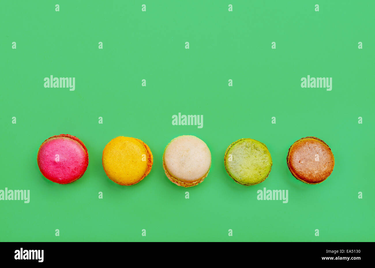 Colorés et savoureux Macarons français sur fond vert.vue d'en haut. Banque D'Images