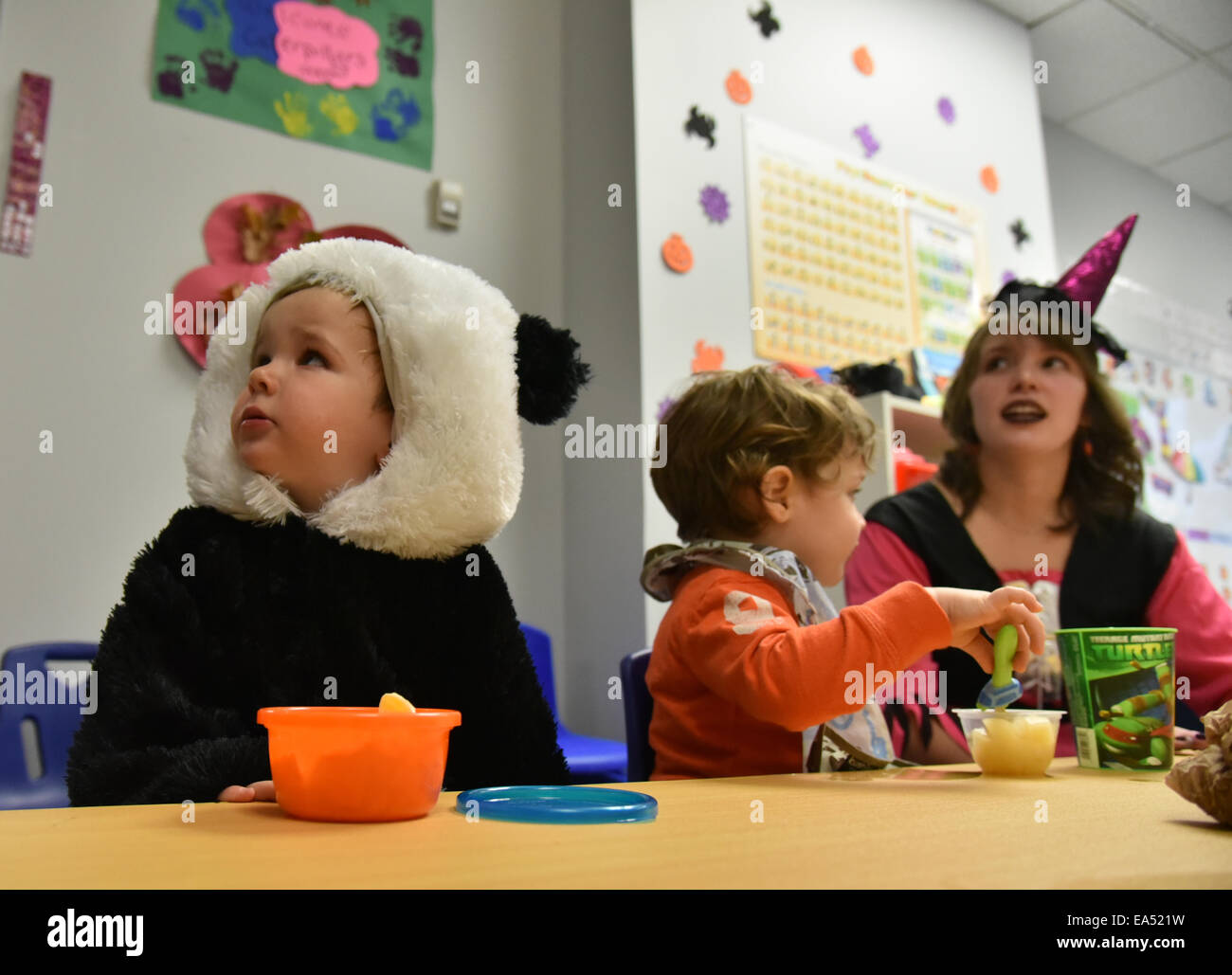 Les enfants d'âge préscolaire avec leur enseignant en robe de soirée à leur classe de maternelle à l'halloween Banque D'Images