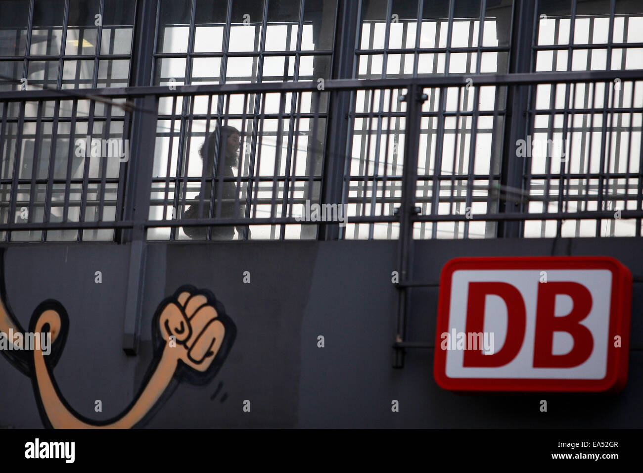Berlin, Allemagne. Nov 6, 2014. Un passager promenades à travers une plate-forme avec le logo de la Compagnie des chemins de fer allemande Deutsche Bahn (DB) à Berlin, Friedrich gare de Berlin, Allemagne, le 6 novembre 2014. Les conducteurs de train allemands ont organisé une grève record aux compagnie de la Deutsche Bahn (DB) le mercredi, ignorant les critiques et les appels des passagers, les entreprises et le gouvernement. La grève a commencé avec les conducteurs de train de fret de la DB fixant leur emploi comme prévu le mercredi après-midi, et les conducteurs de train de passagers impliqués tôt jeudi. © Zhang Fan/Xinhua/Alamy Live News Banque D'Images