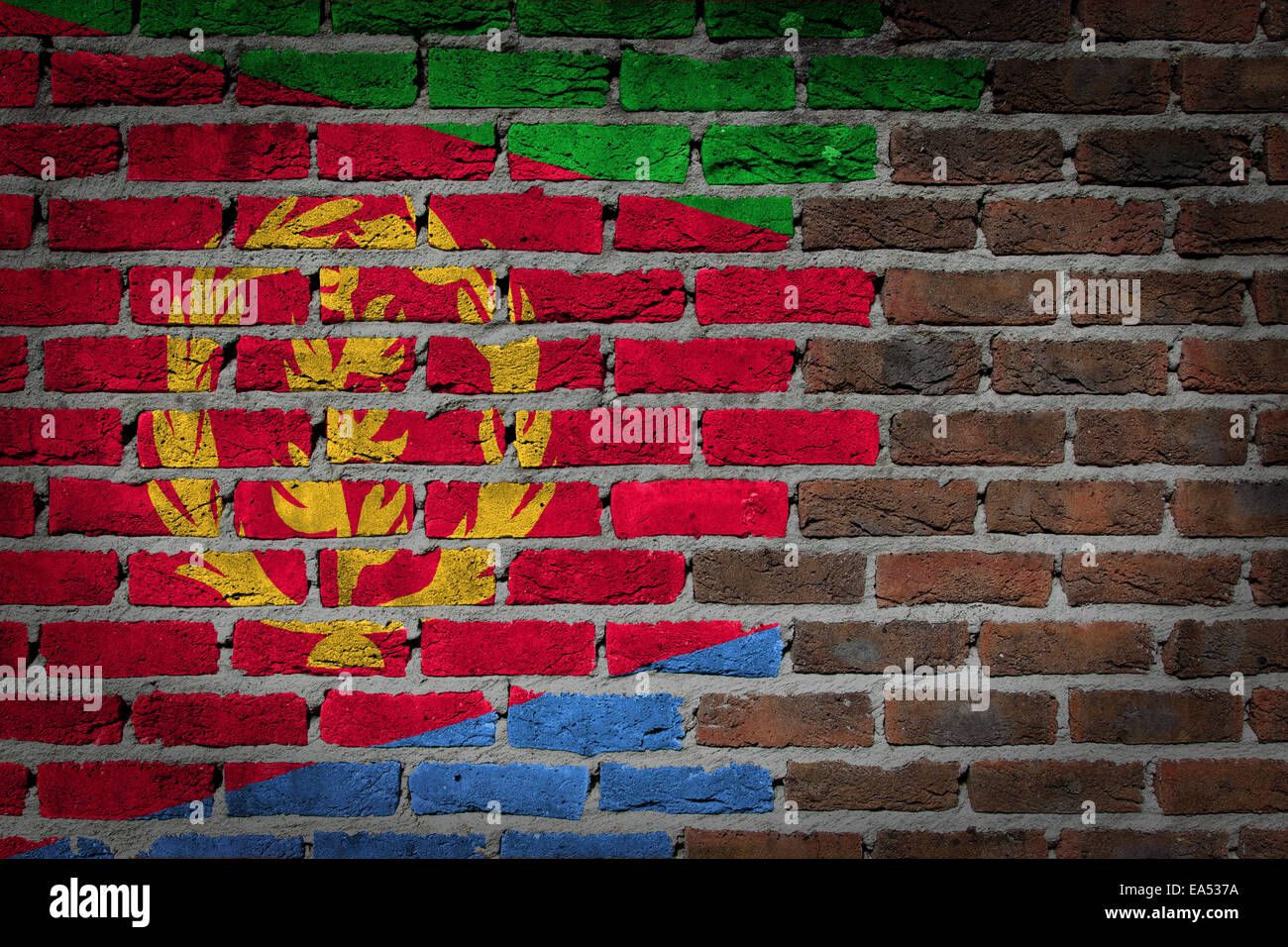 Très vieux mur en brique rouge foncé texture avec drapeau - Érythrée Banque D'Images