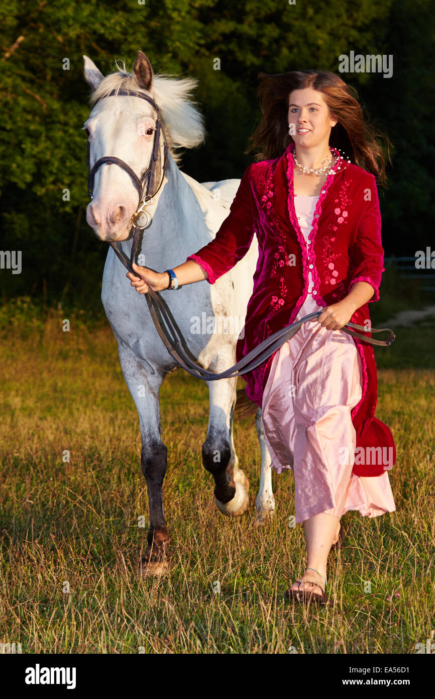 Jeune femme avec cheval représenté sur une soirée d'été sur le haut d'une colline Banque D'Images