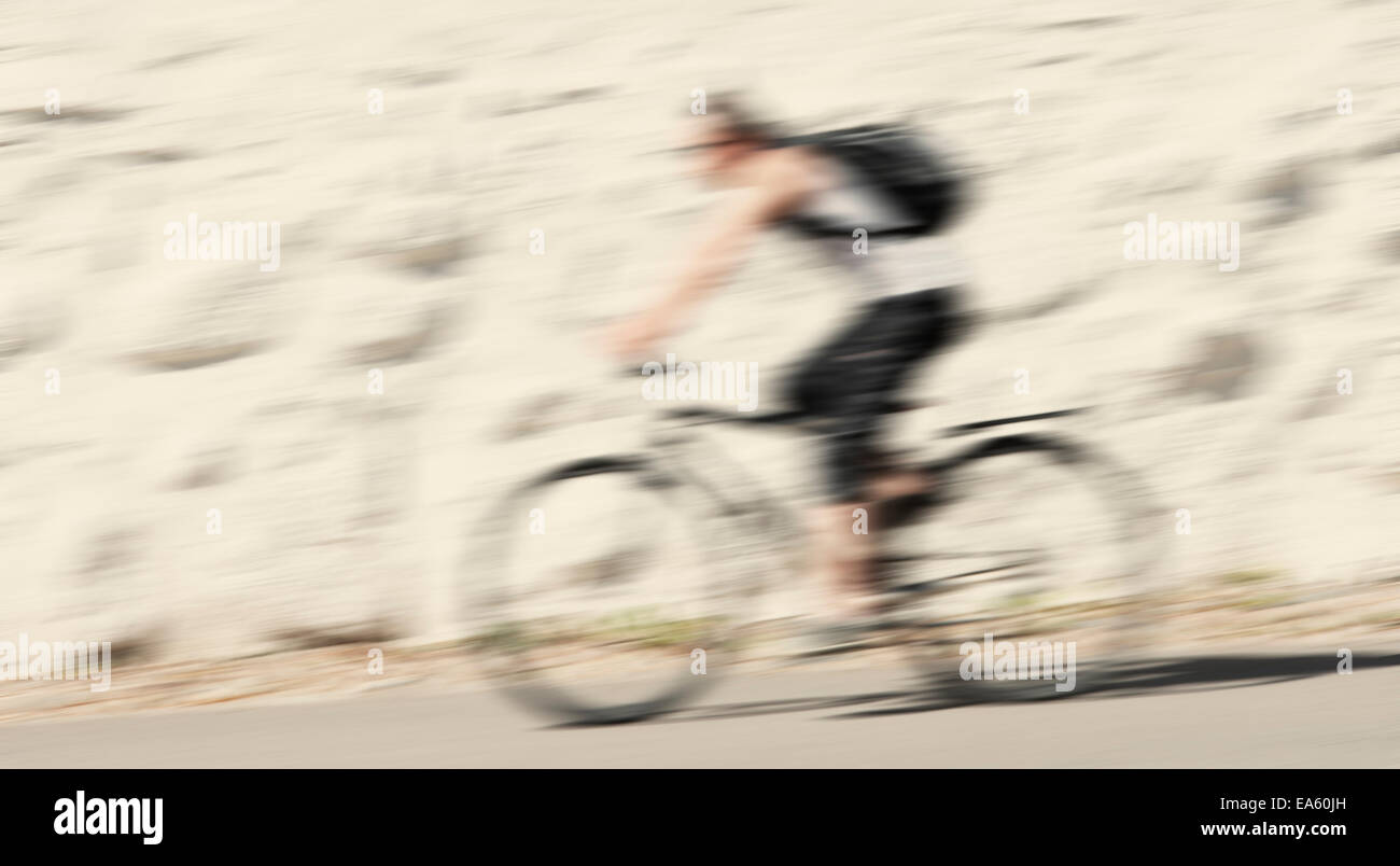 Blurred motion de man riding a bicycle Banque D'Images