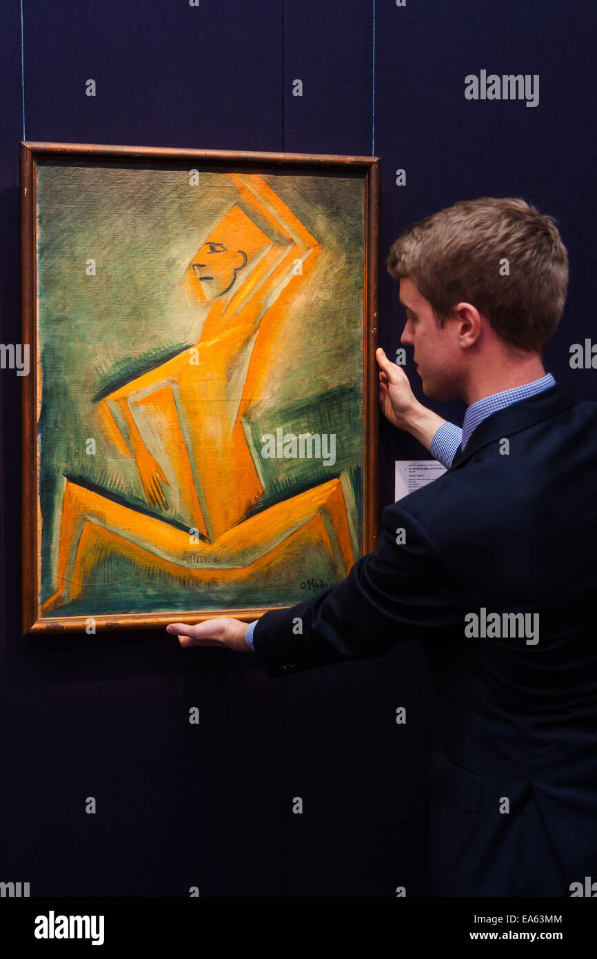Londres, Royaume-Uni. 7 novembre, 2014. Sotheby's est de tenir sa séance inaugurale 20ème Siècle Art- une perspective différente vente le 12 novembre à Londres, où les collectionneurs auront la possibilité d'acquérir quelques exemples très estimé de l'avant-garde et l'art abstrait. Photo : Sotheby's tableaux européens Richard Lowkes spécialiste règle la pendaison de 'Figure' cubiste par Otakar Kubin, un élément important de la redécouverte de l'artiste période cubiste. d'une valeur estimée jusqu'à £120 000. Crédit : Paul Davey/Alamy Live News Banque D'Images