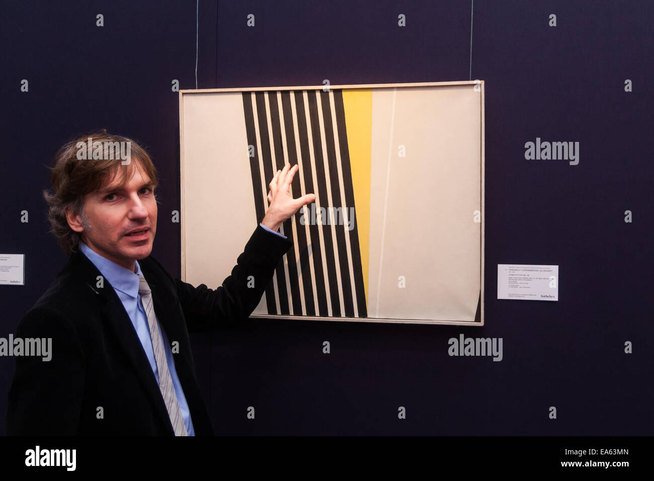 Londres, Royaume-Uni. 7 novembre, 2014. Sotheby's est de tenir sa séance inaugurale 20ème Siècle Art- une perspective différente vente le 12 novembre à Londres, où les collectionneurs auront la possibilité d'acquérir quelques exemples très estimé de l'avant-garde et l'art abstrait. Photo : Matthieu Floris, vice-directeur de Sotheby's Press Office traite de Friedrich Voremberge-Gildewart' Composition no. 56, ce qui est prévu pour aller chercher jusqu'à £180 000. Crédit : Paul Davey/Alamy Live News Banque D'Images