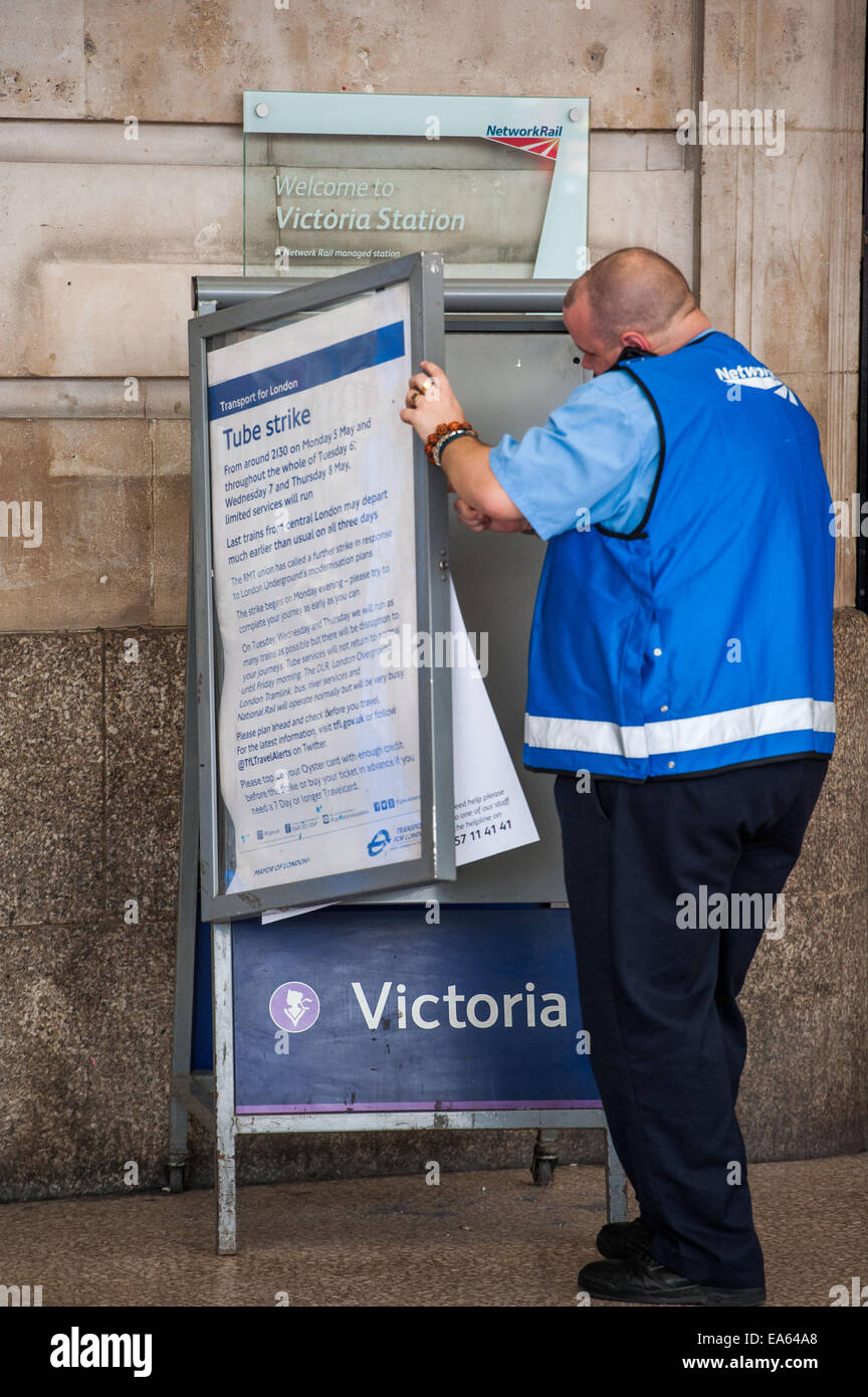 Un travailleur Network Rail supprime un poster d'information a annoncé la grève du tube prévu cette semaine. L'EGI ont suspendu l'action industrielle. Où : London, England, United Kingdom Quand : 05 mai 2014 Banque D'Images