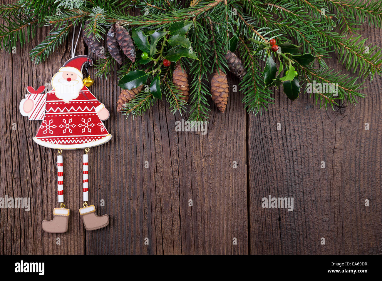 Père Noël avec des branches de sapin sur fond de bois Banque D'Images
