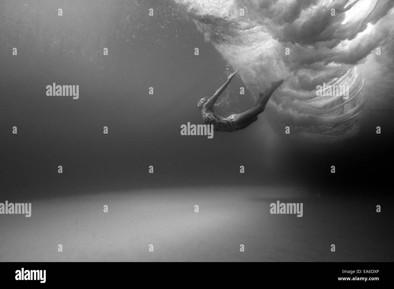 Woman swimming underwater Banque D'Images