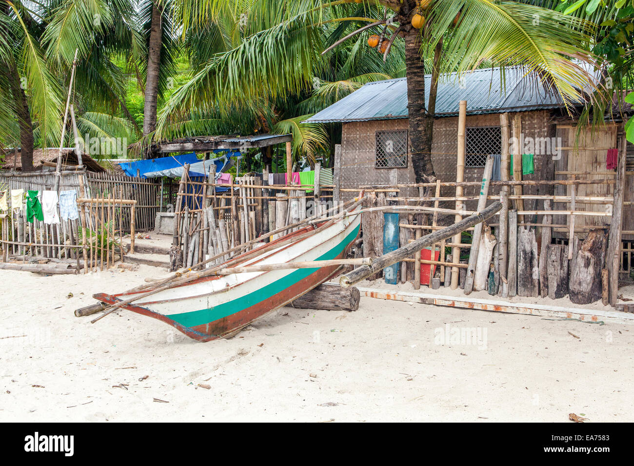 Nueva Valencia, l'île de Guimaras, Philippines - un petit ponton bateau de pêche est attaché à une clôture de bois flotté. Banque D'Images