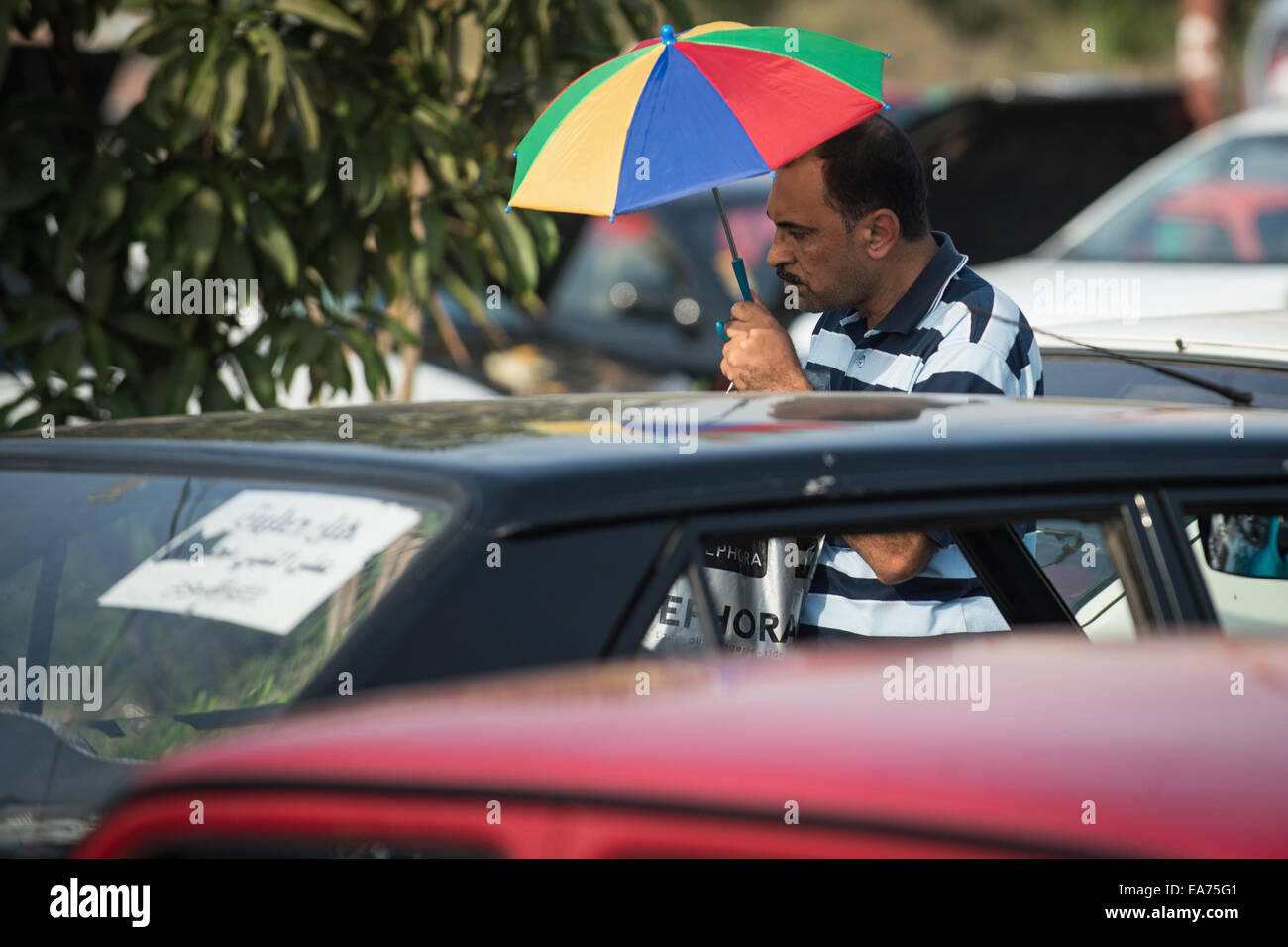 Le Caire. 17 Oct, 2014. Un homme marche dans un marché de l'occasion à Nasr City, banlieue à l'Est du Caire, en Égypte, en juin17, 2014. Certains propriétaires de voitures, vendeurs, acheteurs et vendeurs sur l'énorme marché voiture d'occasion se sont plaints de la récession dans le marché en raison de la récente hausse de prix résultant de la dernière réduction des subventions de l'énergie qu'augmenté les prix du carburant, le gaz naturel, l'électricité et autres, faisant valoir les plans de réforme économique du pays affecté le marché de seconde main. © Chaoyue Pan/Xinhua/Alamy Live News Banque D'Images