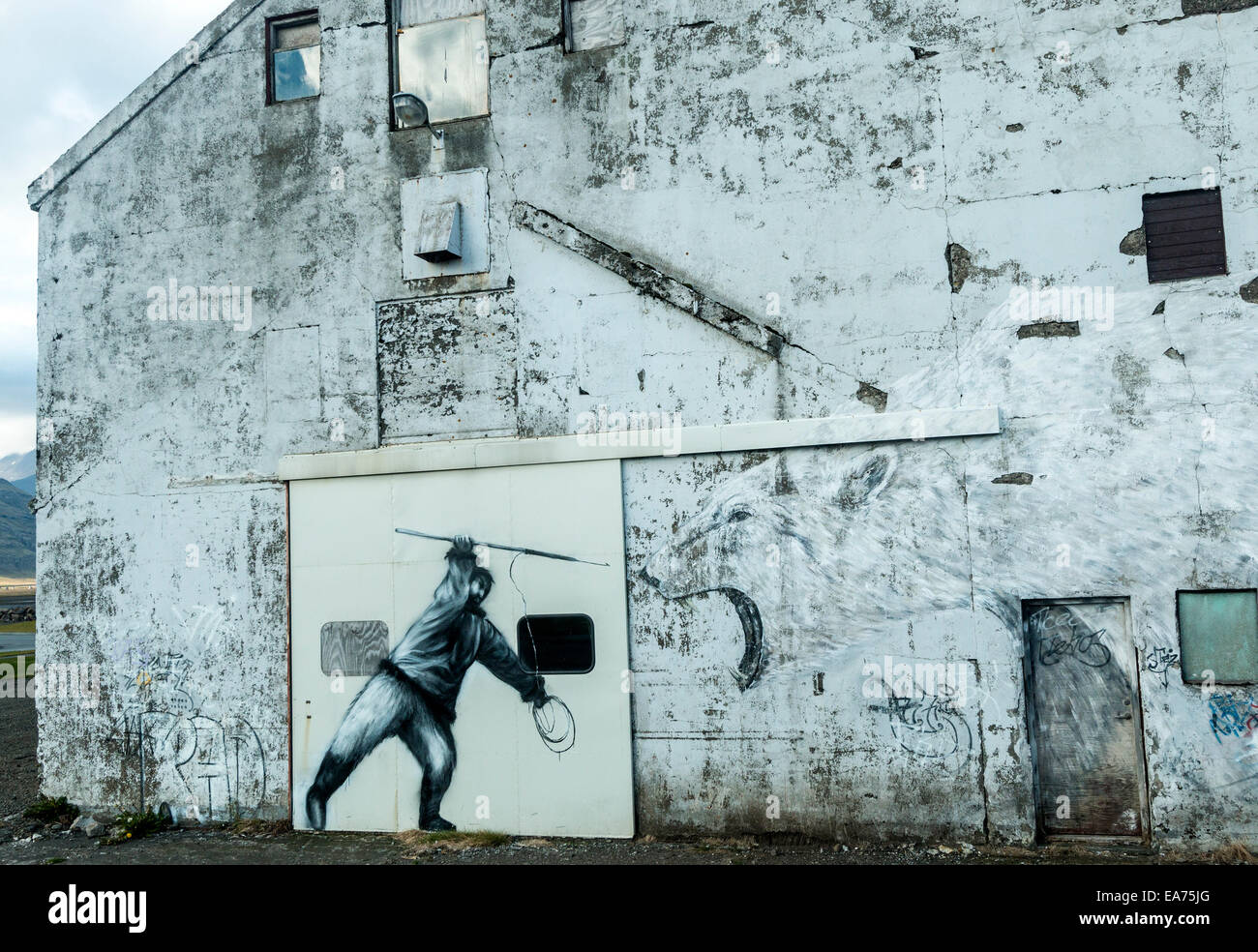 Peinture murale représentant chasseur inuit sur le côté d'un immeuble dans l'Est de l'Islande ville de Reydarfjordur. Banque D'Images
