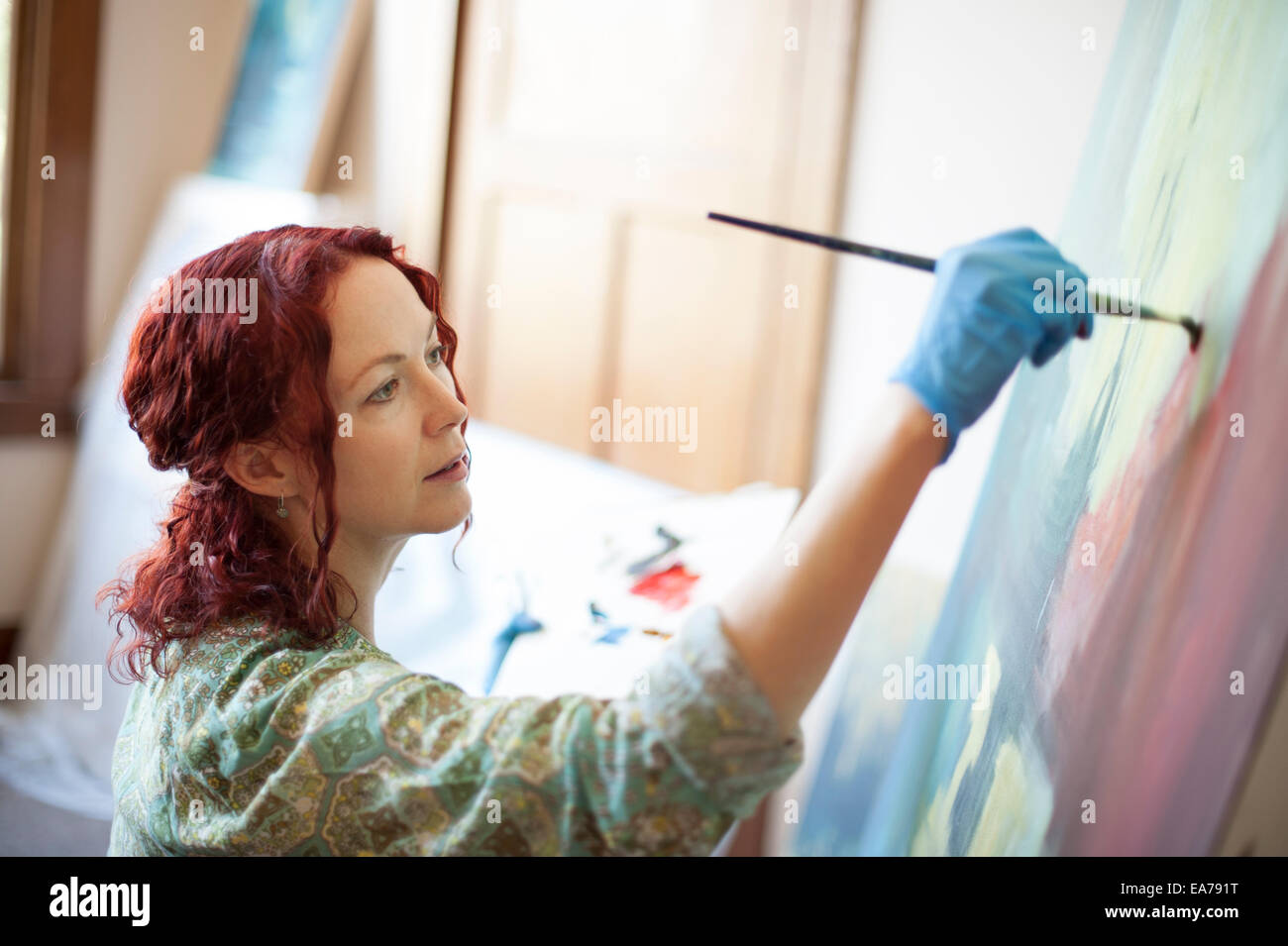 Portrait of middle-aged woman painting on canvas Banque D'Images