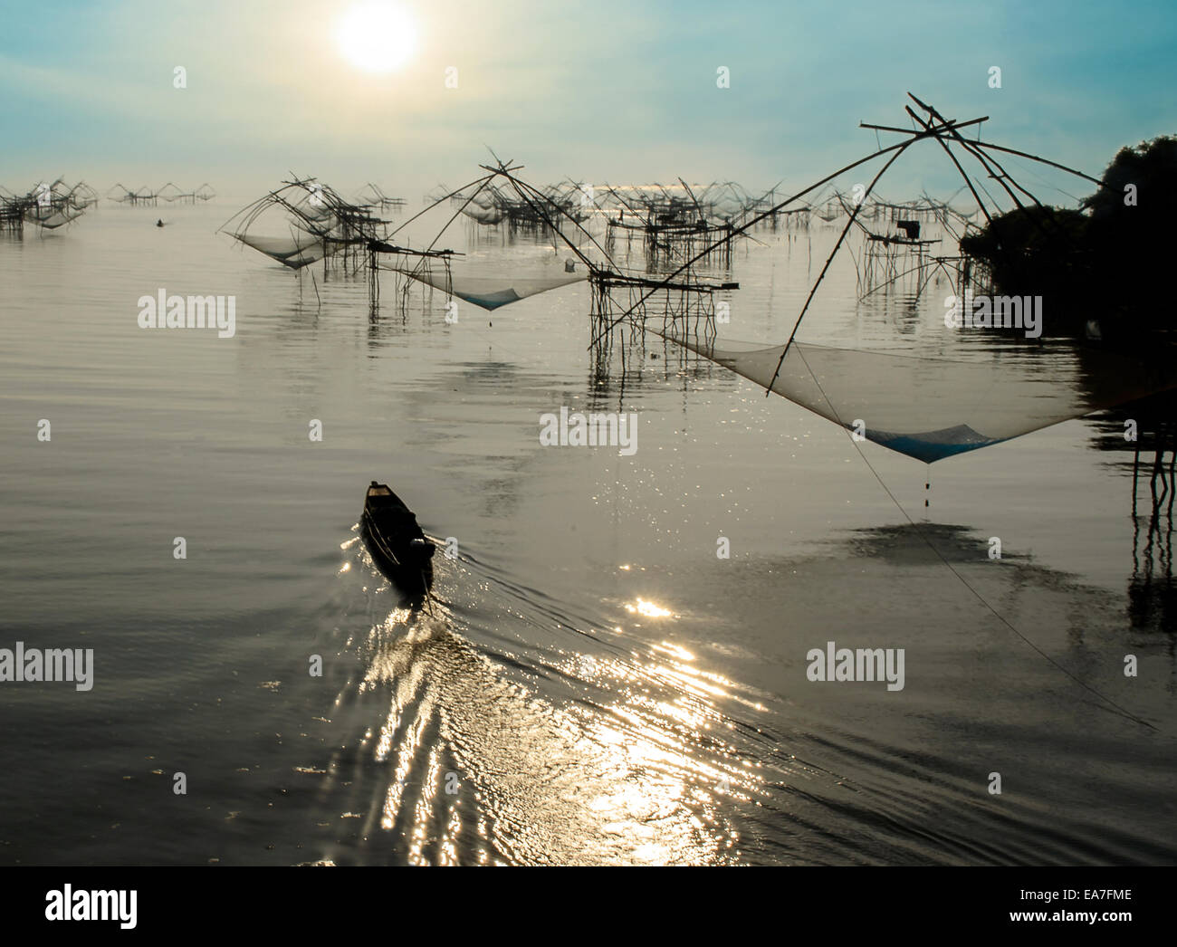 Le bateau de pêcheur et des poissons carrés dans Net Morning Sunrise au lac Songkla en Thaïlande. Banque D'Images