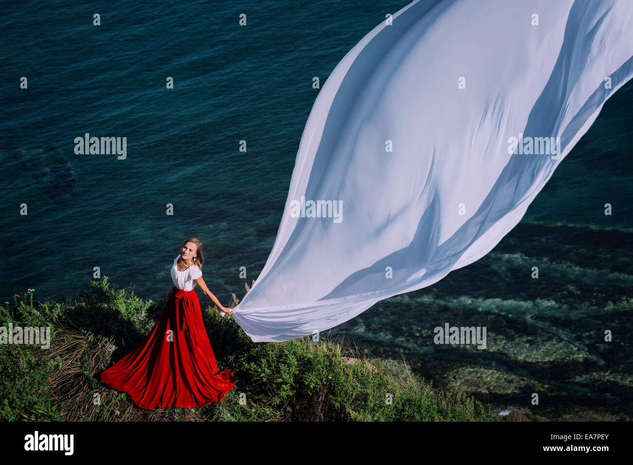 Belle fille avec tissu blanc sur fond de mer Banque D'Images