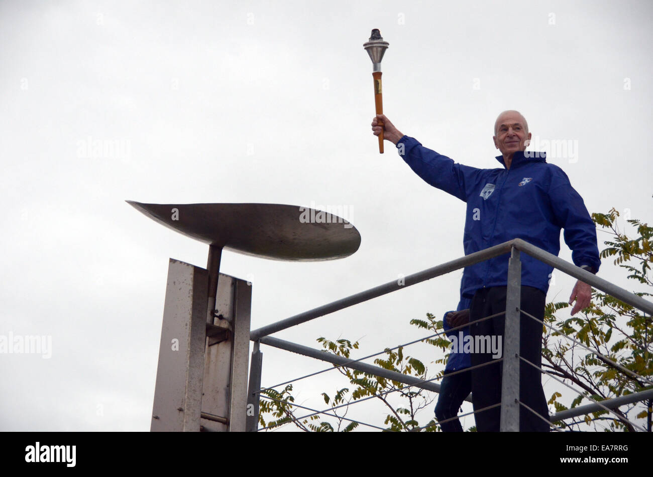 Athènes, Grèce. Nov 8, 2014. Athènes, flamme pour le 32e Marathon d'Athènes à l'Authentique Ville de Marathon le samedi. Nov 8, 2014. George Hirsch, l'un des fondateurs de le Marathon de New York, des lumières l'autel avec la flamme pour le 32e Marathon d'Athènes à l'Authentique Ville de Marathon le samedi, Novembre 8, 2014. La cérémonie a eu lieu en tant que porteur de 35 000 engins jusqu'à prendre part à la classique course de Marathon à Athènes le 9 novembre. Credit : Marios Lolos/Xinhua/Alamy Live News Banque D'Images