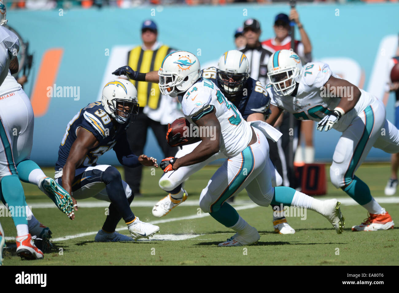 Jardins de Miami en Floride, USA. 2e Nov, 2014. Damien Williams # 34 de Miami se précipite passé Marcus Gilchrist # 38 et Jarret Johnson # 96 de San Diego au cours de la NFL football match entre les dauphins de Miami et San Diego Chargers au Sun Life Stadium de Miami Gardens FL. Les Dauphins défait les chargeurs 37-0. © csm/Alamy Live News Banque D'Images