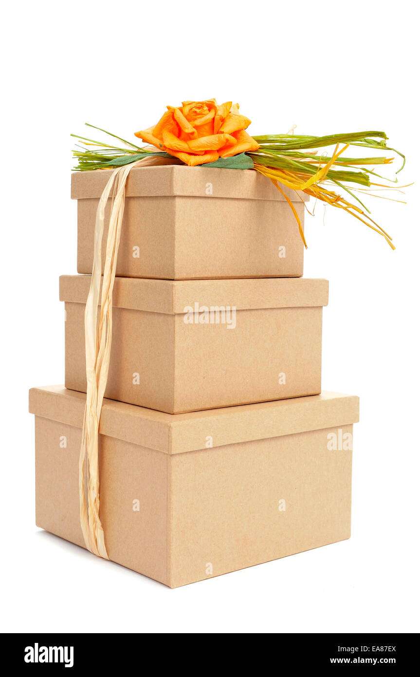 Certaines boîtes cadeau attaché avec du raphia naturel de diverses couleurs et surmonté d'une fleur sur fond blanc Banque D'Images