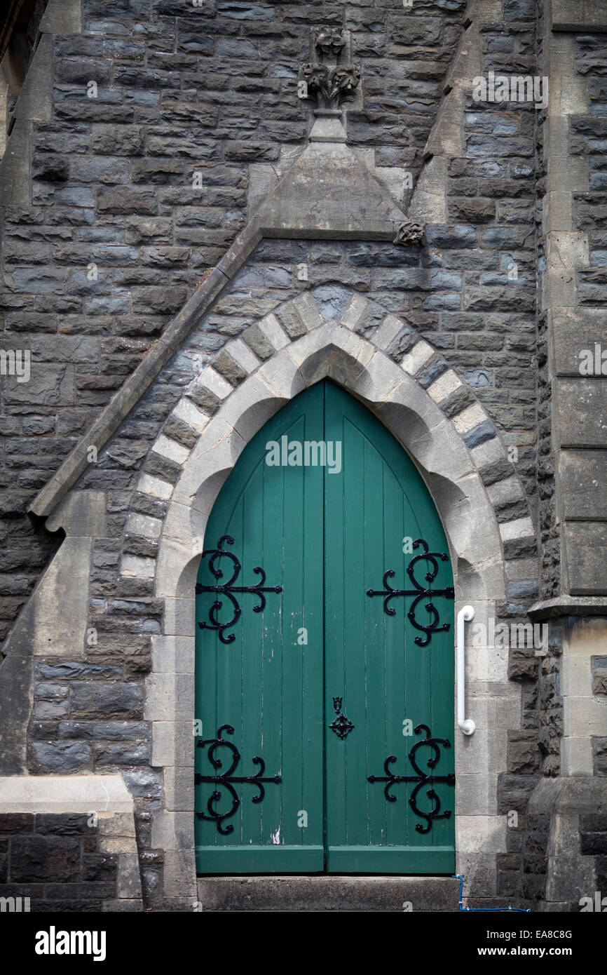 Photo verticale d'une ancienne porte en bois vert sur une église en pierre à Carmarthen, Carmarthenshire, au sud ouest du pays de Galles. Il dispose d'un ar Banque D'Images