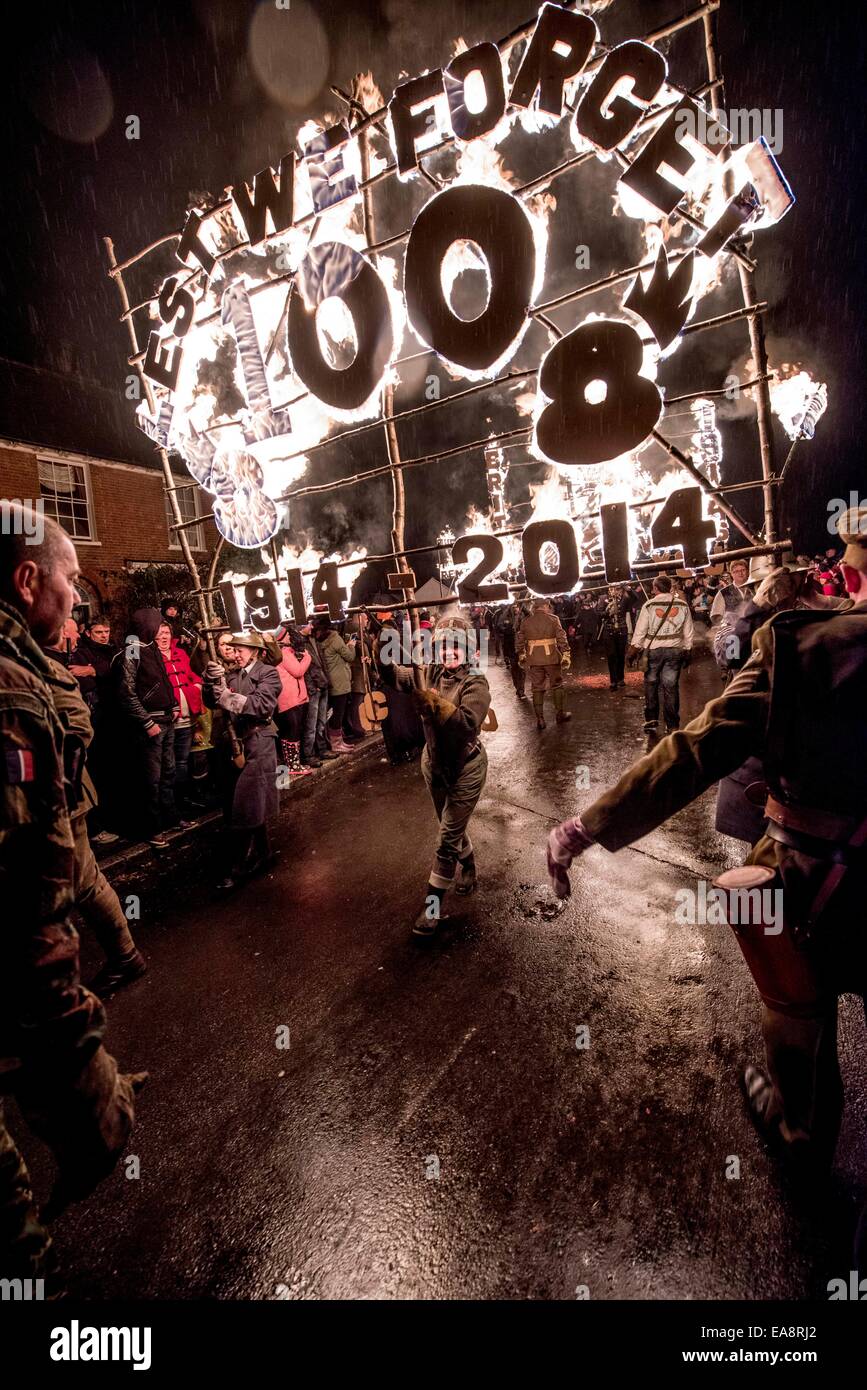 Procession de joie pour la mémoire. Spectateurs alignés le long des rues de l'East Sussex Village de East Hoathly near Lewes hier soir pour regarder le feu embrase bannières réalisées comme un acte de souvenir, en route vers une immense sculpture de bois et feu d'artifice. La société a célébré le Carnaval villageois tombé dans la première et la seconde guerre mondiale depuis 90 ans. Une bannière avec nous nous souviendrons, coquelicots et le nombre 100 portés par le centre du village. Banque D'Images