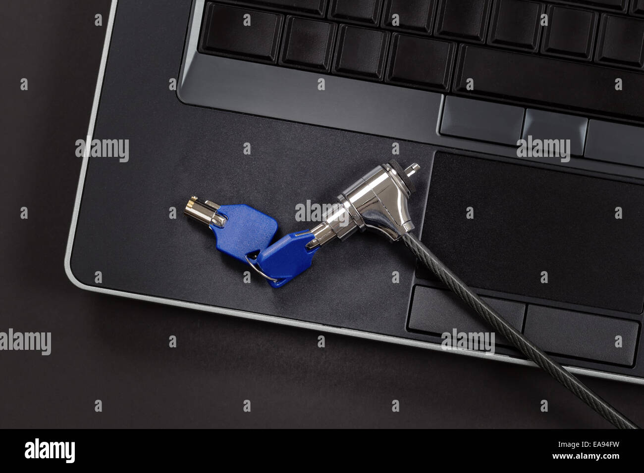 Ordinateur avec serrure et clé, la lumière sur la partie principale de la serrure, sur fond noir Banque D'Images