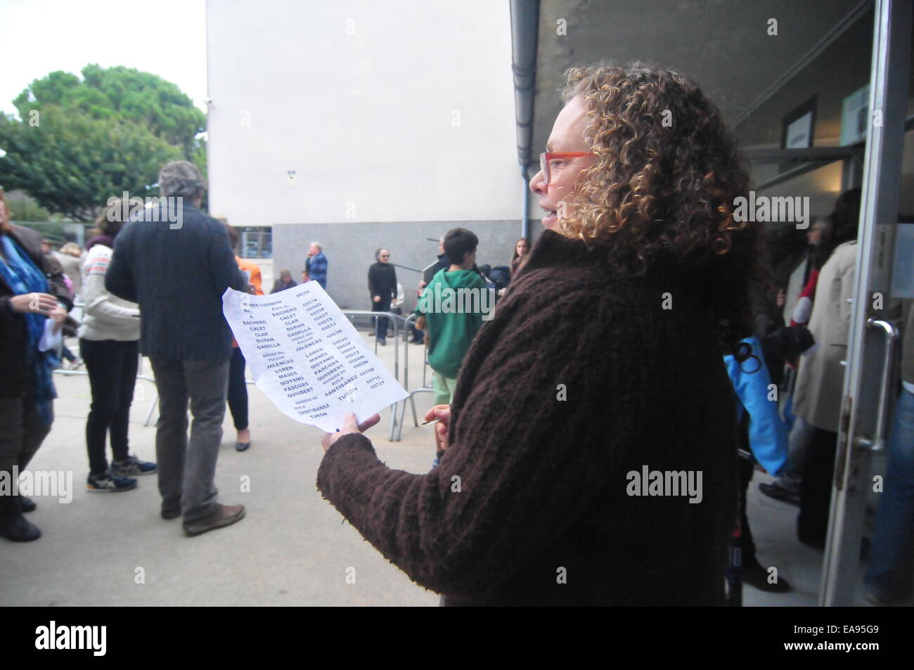 La Catalogne de la journée de consultation -Référendum- Sant Cugat (Barcelone, Novembre 9th, 2014) Bénévole prêt à aider les électeurs avec une liste des tableaux correspondants avec les noms de famille Banque D'Images