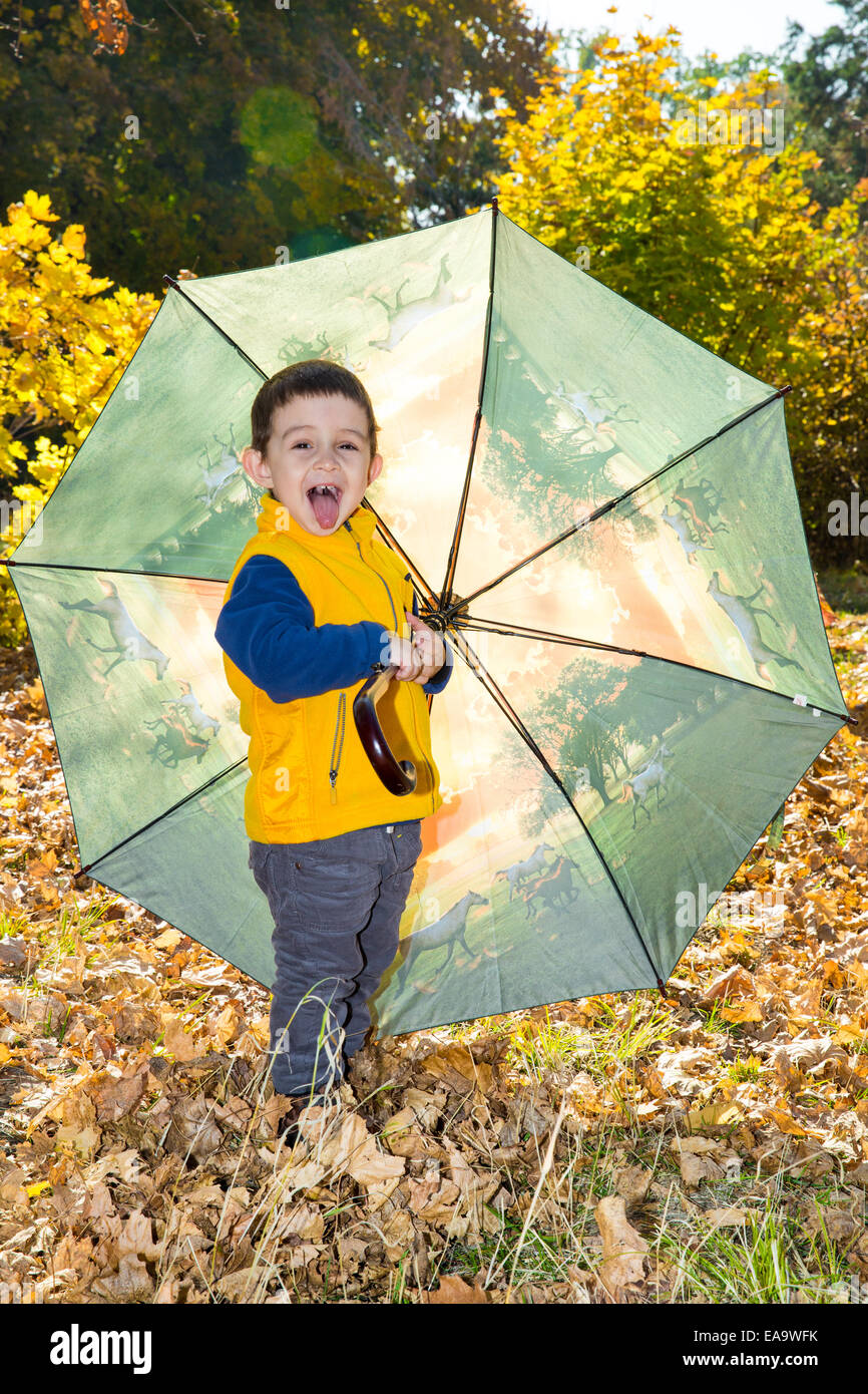 De l'automne. Adorable bébé garçon de deux ans avec parapluie in autumn park Banque D'Images
