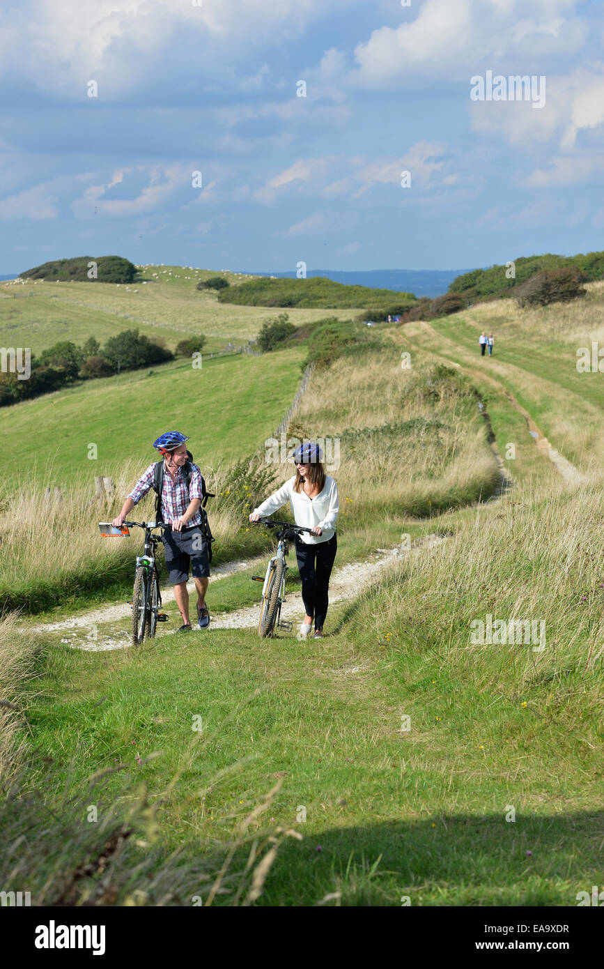 Un jeune couple à vélo le long de la South Downs Way à Butts Brow, Willingdon, près de Eastbourne, East Sussex. UK Banque D'Images