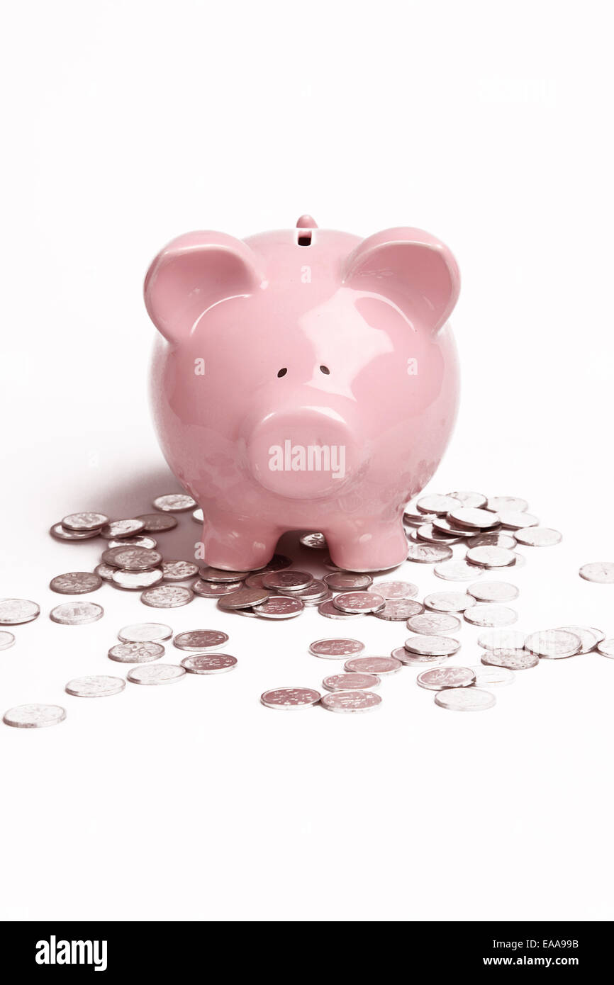 Pink Piggy Bank on isolé sur fond blanc avec des pièces Banque D'Images