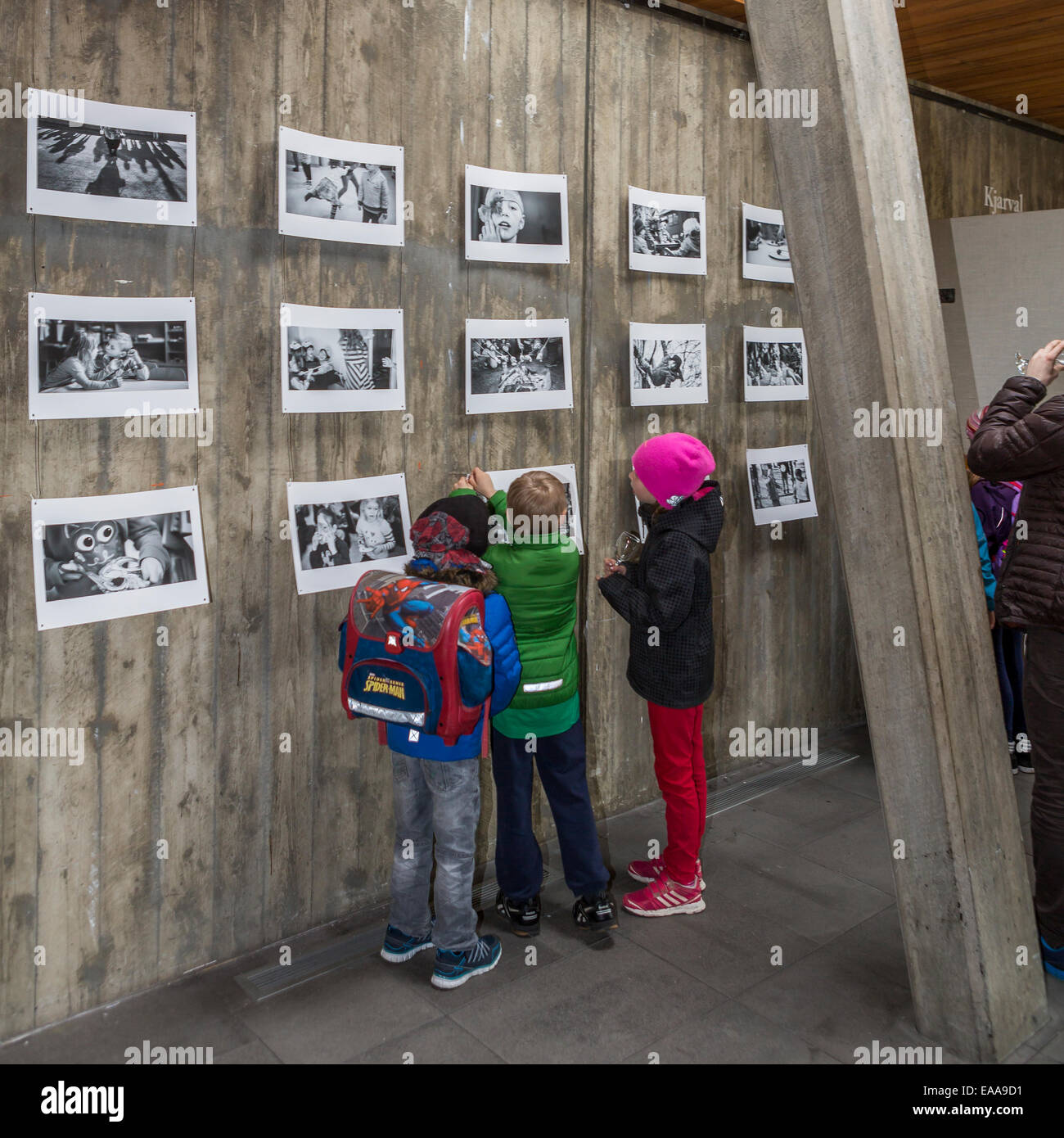 Les enfants à une exposition de photos, regarder des images d'eux-mêmes. Reykjavik, Islande Banque D'Images