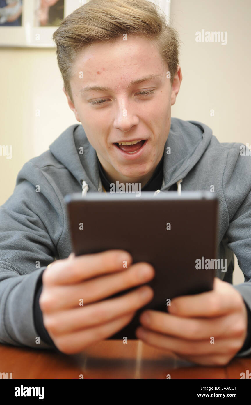 Teenage Boy en utilisant un Apple iPad Mini Banque D'Images
