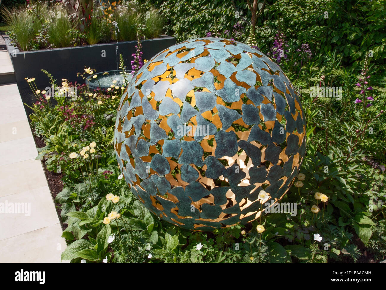 Chelsea Flower Show. Sphère métal architectural avec un petit étang formelle ronde derrière les deux dans un lit double composé de principalement Banque D'Images
