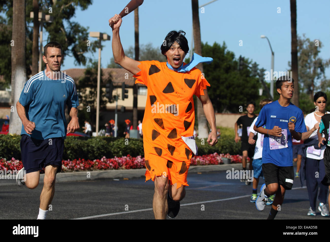 Runner habillé comme Fred Flintstone participe à une course sur route de 5k (Dino Dash) à Tustin en Californie Banque D'Images