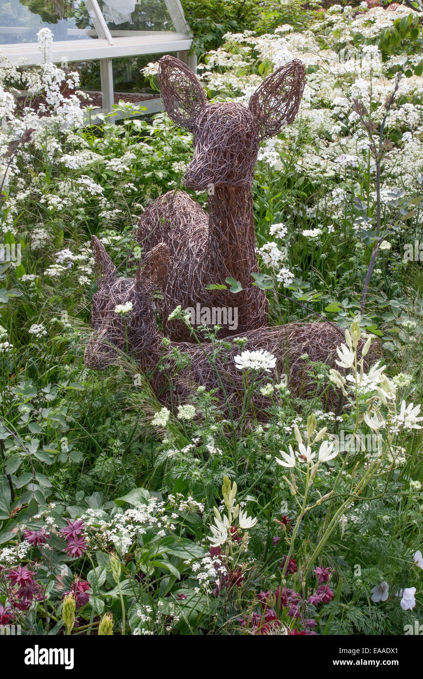 Chelsea Flower Show 2014. Brins entrelacés et sculptée en métal pour former deux cerfs dans parmi une plantation pérennes mixtes Banque D'Images