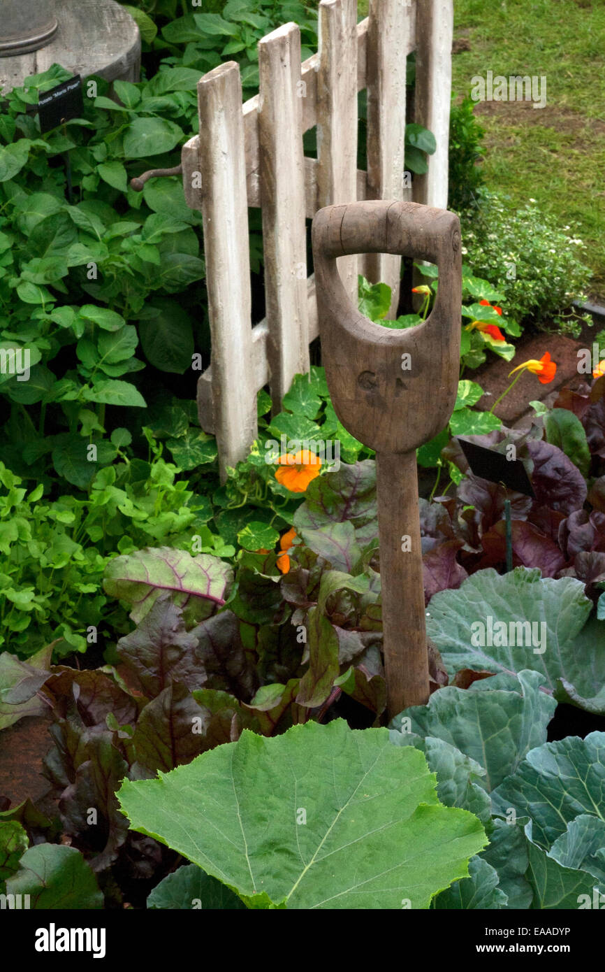Chelsea Flower Show 2014. Petite porte en bois et la poignée d'une antique dans la fourchette entre un mélange de légumes Banque D'Images