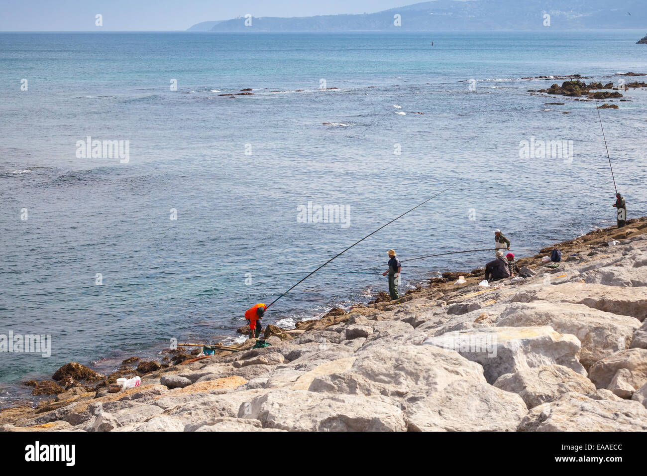 Tanger, Maroc - Mars 22, 2014 : l'arabe avec les pêcheurs de longues tiges une position sur la côte de l'océan Atlantique à la baie de Tanger, Mor Banque D'Images