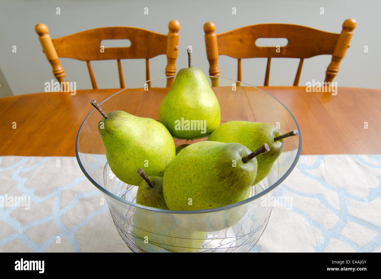 Poires : Les poires dans un bol en verre créer un centre de table décoratif pour une table à manger. Banque D'Images